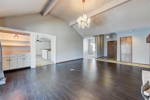 unfurnished living room with ceiling fan with notable chandelier, high vaulted ceiling, dark wood finished floors, baseboards, and beam ceiling
