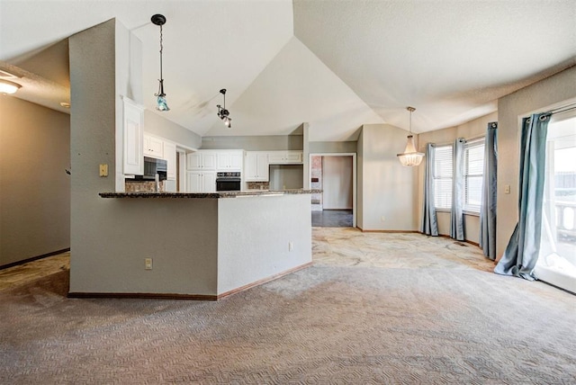 kitchen featuring stainless steel microwave, oven, light carpet, and lofted ceiling