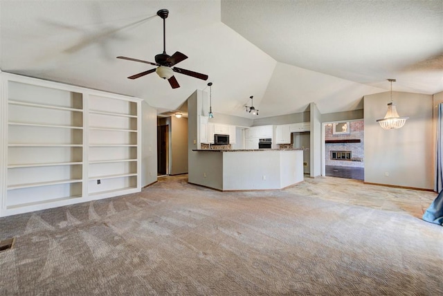 unfurnished living room with ceiling fan, light colored carpet, vaulted ceiling, and a fireplace