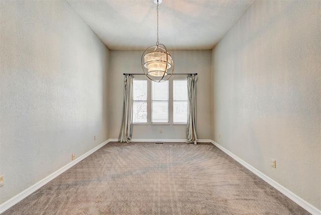 unfurnished room with baseboards, carpet flooring, and a notable chandelier