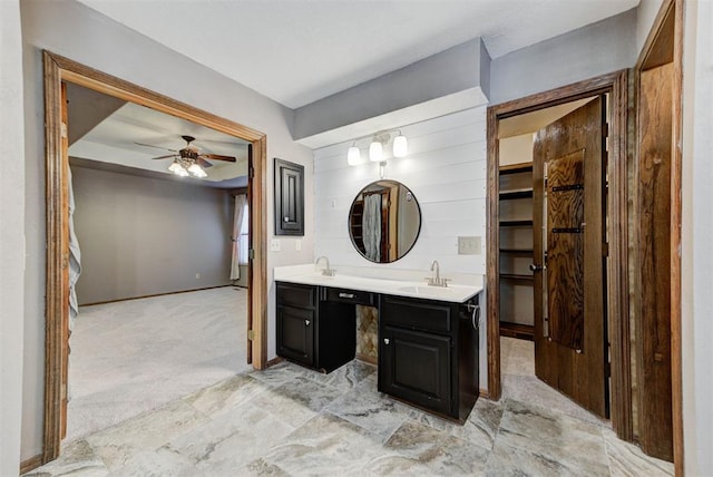 bathroom featuring a spacious closet, a sink, double vanity, and a ceiling fan