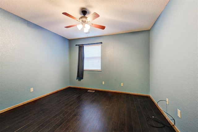 empty room featuring a textured wall, hardwood / wood-style flooring, baseboards, and ceiling fan