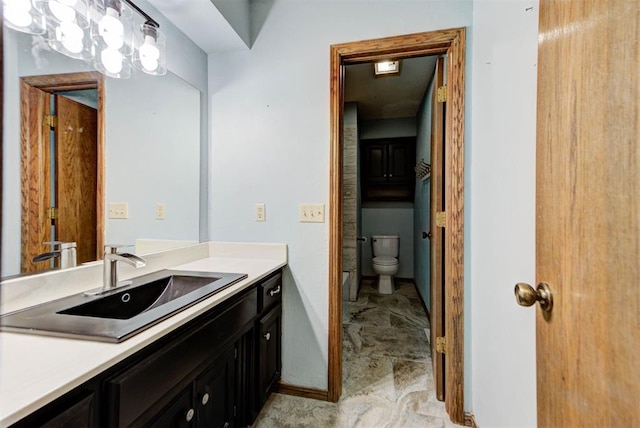 full bathroom featuring toilet, vanity, and baseboards