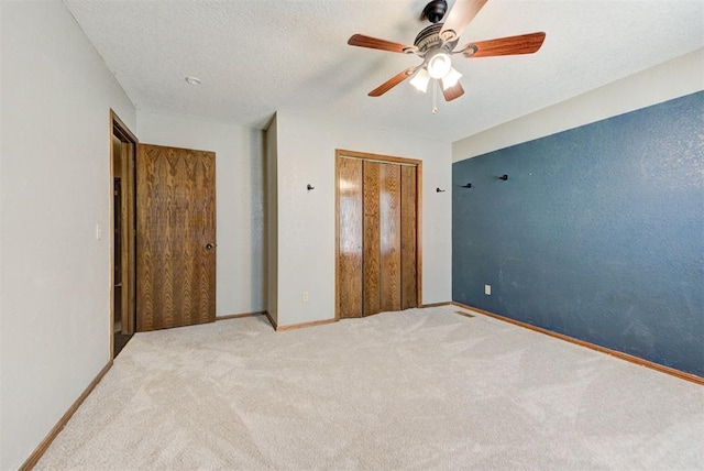 unfurnished bedroom featuring ceiling fan, a closet, baseboards, and carpet floors