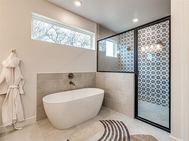 bathroom featuring tile patterned flooring, separate shower and tub, and tile walls