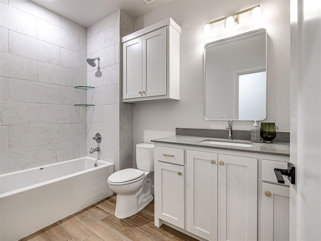 full bathroom with vanity, hardwood / wood-style floors, toilet, and tiled shower / bath