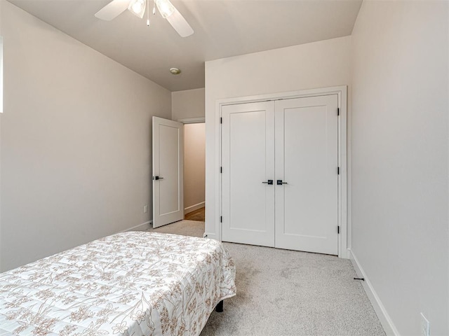 carpeted bedroom with ceiling fan and a closet