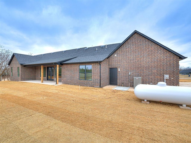 rear view of house featuring central AC, a patio area, and a lawn