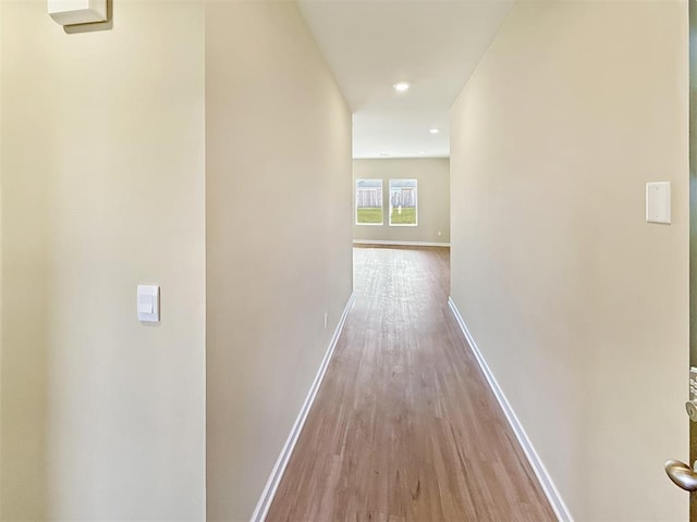 corridor featuring recessed lighting, light wood-style flooring, and baseboards