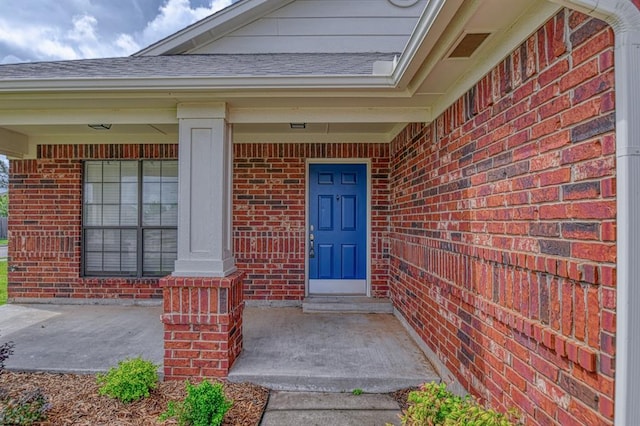 10700 NW 36th Pl, Yukon, OK 73099 - entrance to property featuring brick siding, covered porch, and roof with shingles