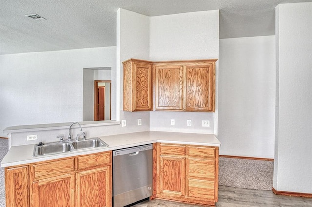 10700 NW 36th Pl, Yukon, OK 73099 - kitchen with dishwasher, a sink, light wood-style flooring, light countertops, and a textured ceiling