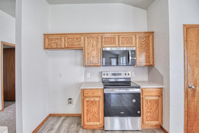 10700 NW 36th Pl, Yukon, OK 73099 - kitchen featuring stainless steel appliances, light wood-type flooring, light countertops, baseboards, and a textured wall