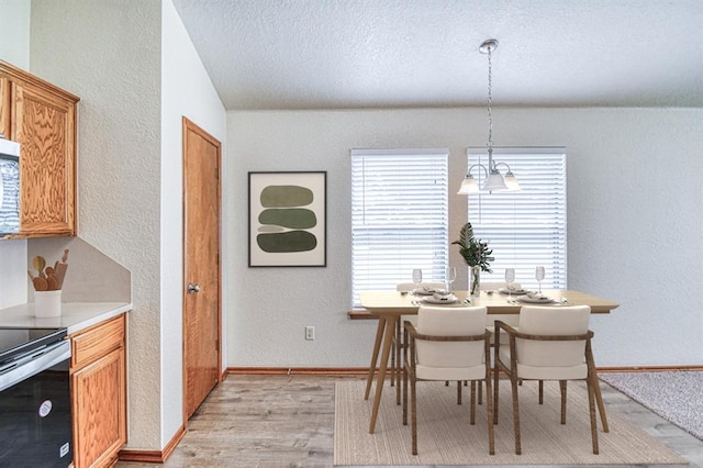 10700 NW 36th Pl, Yukon, OK 73099 - dining room with a textured wall, healthy amount of natural light, light wood-style flooring, a textured ceiling, and baseboards