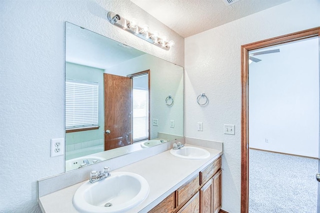 10700 NW 36th Pl, Yukon, OK 73099 - bathroom with a textured wall, double vanity, and a textured ceiling