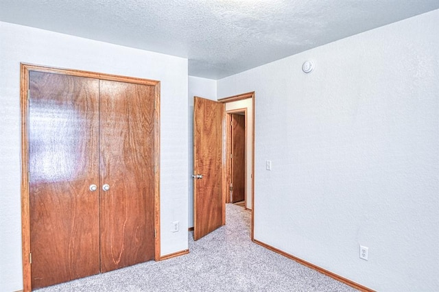 10700 NW 36th Pl, Yukon, OK 73099 - unfurnished bedroom featuring carpet floors, a closet, a textured ceiling, and baseboards