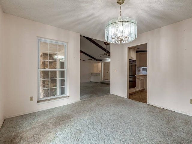 unfurnished dining area with ceiling fan with notable chandelier, a textured ceiling, and carpet