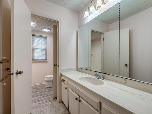 bathroom with vanity, a textured ceiling, and toilet