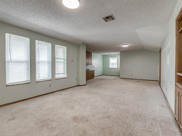 empty room with light carpet and a textured ceiling