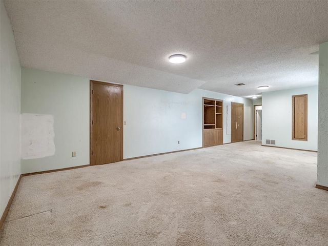 spare room with a textured ceiling and carpet