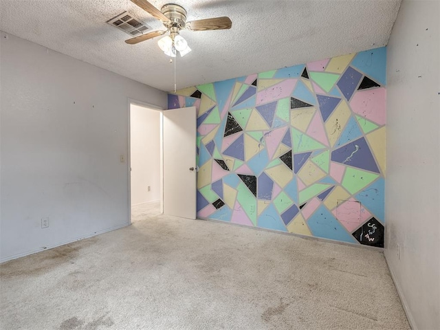 empty room with ceiling fan, carpet floors, and a textured ceiling