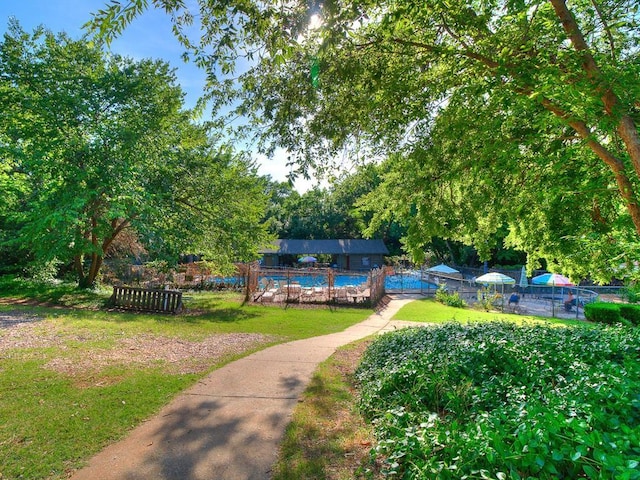 view of property's community featuring a swimming pool and a lawn