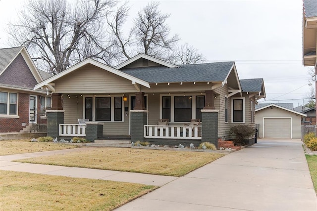 craftsman-style home featuring a garage, an outdoor structure, a front lawn, and a porch