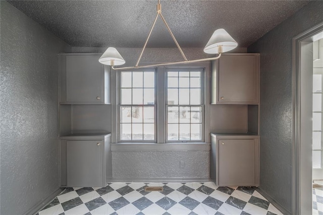 unfurnished dining area with a textured ceiling