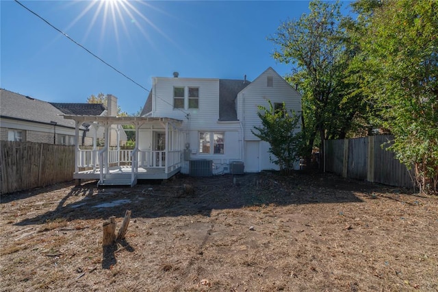 back of property with a wooden deck, central AC, and a pergola