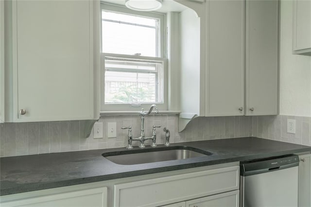 3125 NW 24th St, Oklahoma City, OK 73107 - kitchen with stainless steel dishwasher, a sink, dark countertops, and backsplash