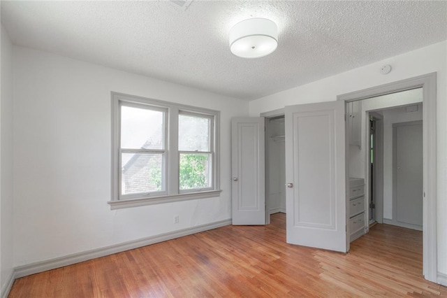 3125 NW 24th St, Oklahoma City, OK 73107 - unfurnished bedroom featuring a textured ceiling, light wood-type flooring, baseboards, and a closet