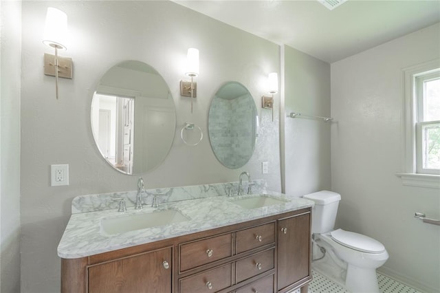 3125 NW 24th St, Oklahoma City, OK 73107 - full bathroom featuring toilet, double vanity, and baseboards