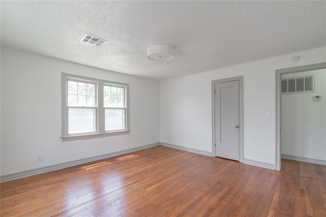 3125 NW 24th St, Oklahoma City, OK 73107 - spare room with wood finished floors, a textured ceiling, and baseboards