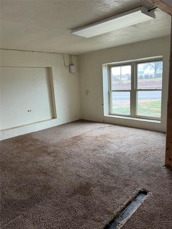 carpeted spare room with a textured ceiling