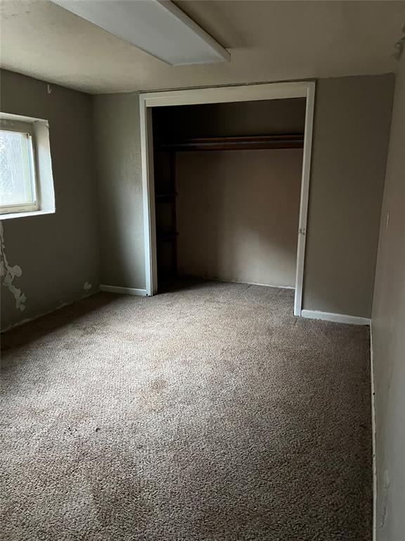 unfurnished bedroom with carpet floors and a closet