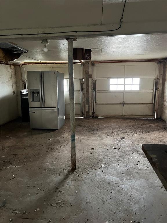 basement featuring stainless steel fridge with ice dispenser