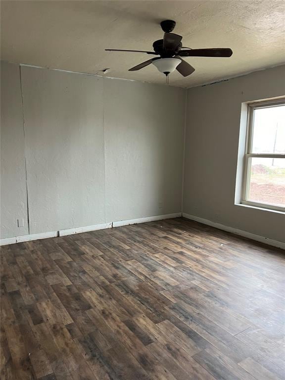 spare room featuring ceiling fan, dark wood-type flooring, and a textured ceiling