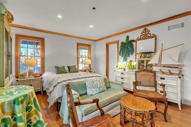 bedroom featuring multiple windows, light wood-type flooring, and visible vents