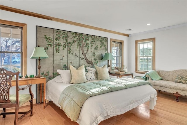 bedroom featuring light wood-style flooring, visible vents, and ornamental molding