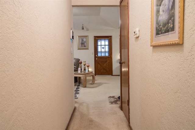 hallway featuring a textured wall and carpet floors