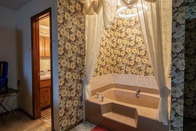 full bathroom featuring baseboards, a garden tub, vanity, and wallpapered walls