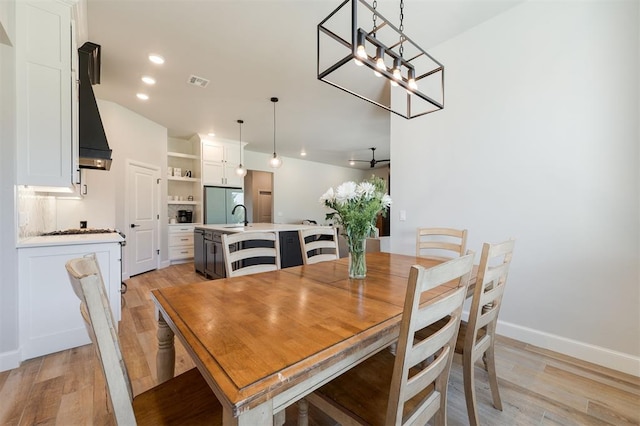 dining space with an inviting chandelier and light hardwood / wood-style flooring