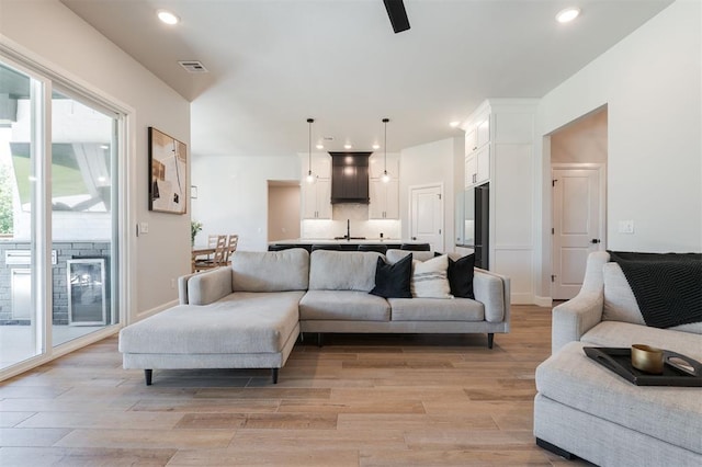 living room with sink and light hardwood / wood-style floors