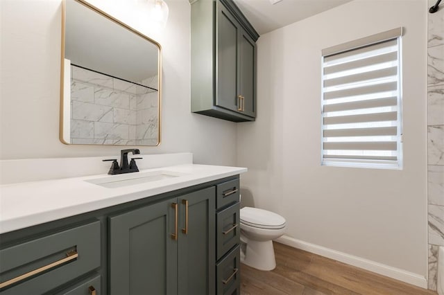 bathroom featuring hardwood / wood-style flooring, vanity, toilet, and a shower