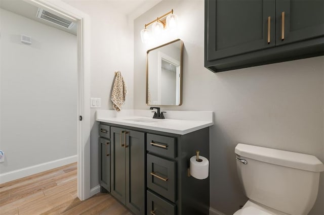 bathroom with vanity, wood-type flooring, and toilet