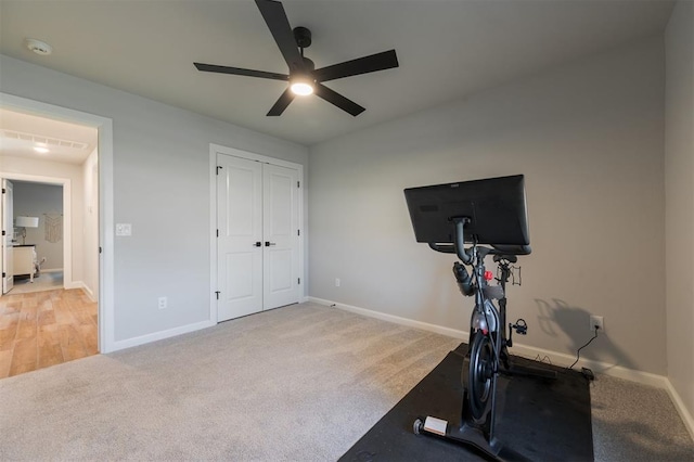 workout area featuring light carpet and ceiling fan