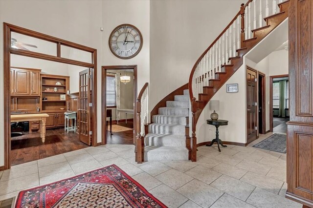 tiled foyer entrance featuring a chandelier and a high ceiling