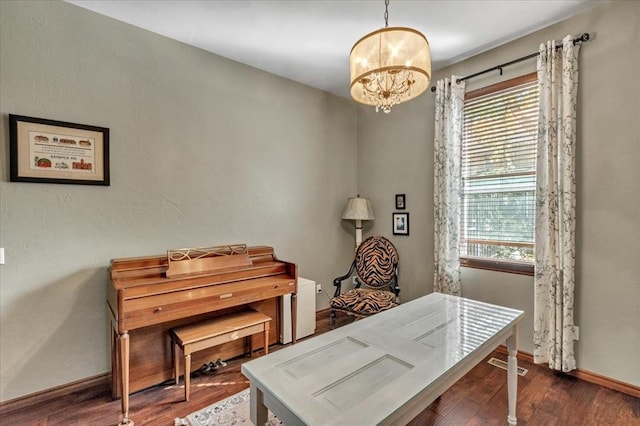 office with dark wood-type flooring, plenty of natural light, and a chandelier