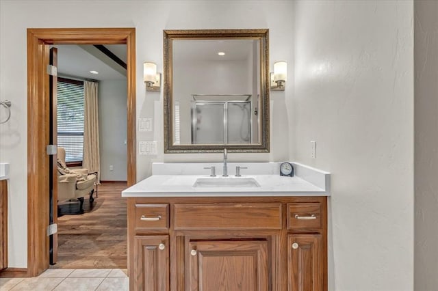 bathroom with an enclosed shower, vanity, and tile patterned flooring