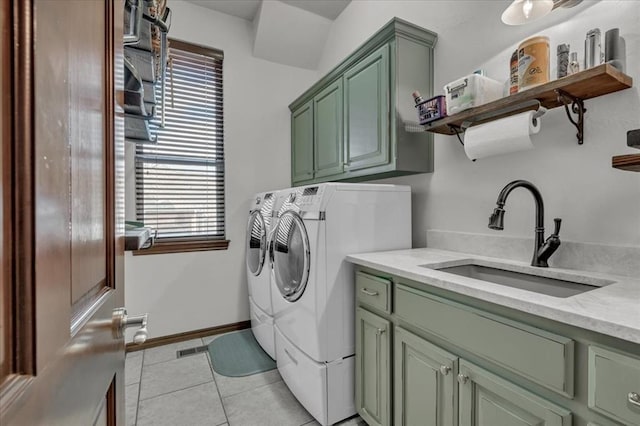 clothes washing area with light tile patterned flooring, cabinets, sink, and washing machine and dryer