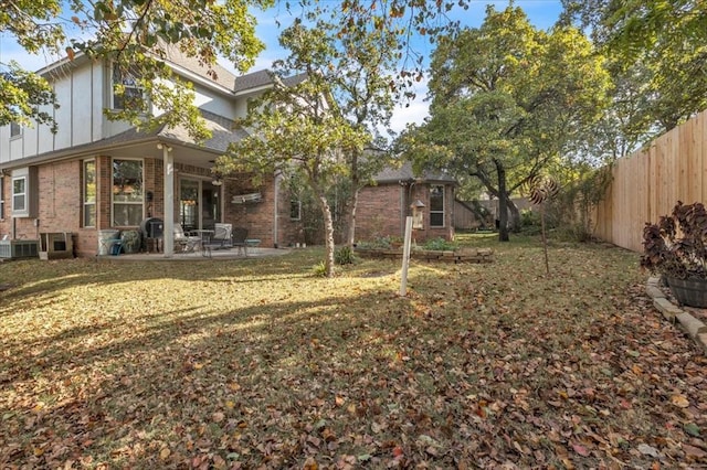 back of property featuring cooling unit, a yard, and a patio